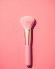 Make up brushes with powder on pink background