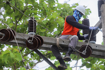 Electricians operate the electrical transmission system on the electricity pole.