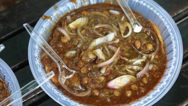 Fried Indian bread kulcha dipped in chana chole.