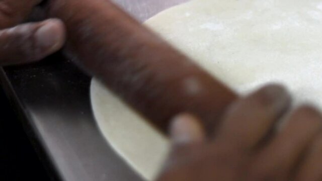 Cooking Indian bread parantha on a huge Indian pan at a street food restaurant. 