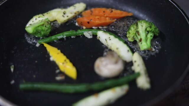 Cooking red sauce, with sauteed vegetables, caramelised onions, red chillies and capsicum on a hot oil pan.