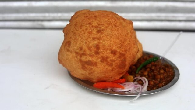 Plate of Indian chole bhature served with onions and chutney. 