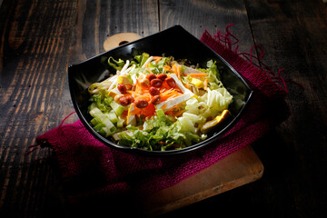 Sliced vegetables and tofu, served in a bowl of black melamine, with chili sour sauce sprinkled with peanuts. Indonesian food is called 