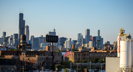 Fototapeta premium Chicago Skyline view of beautiful architecture of the city's wonderful downtown urban district. The cityscape buildings have a warm glows from the sun setting golden hour