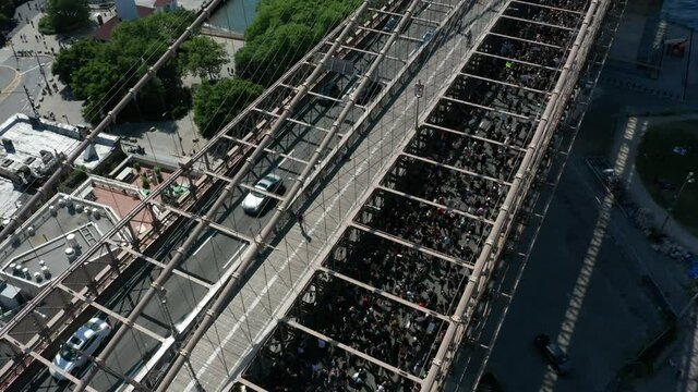 tilting up from Black Lives Matter march to reveal Brooklyn Bridge