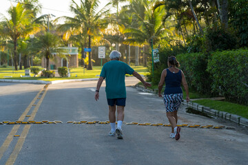 casal da terceira idade caminhando juntos em tarde ensolarada