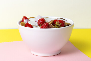 Homemade cereals mini pancake with yogurt, honey and strawberries on colorful background.