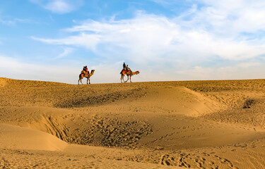 Thar desert sand dunes with view of tourist enjoying camel safari at Jaisalmer Rajasthan India