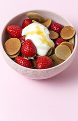 Homemade cereals mini pancake with yogurt, honey and strawberries on colorful background.