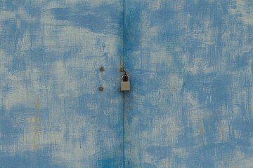 Old garage gates with keyhole. metal blue door and padlock