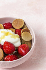 Homemade cereals mini pancake with yogurt, honey and strawberries on colorful background.