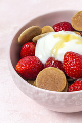 Homemade cereals mini pancake with yogurt, honey and strawberries on colorful background.