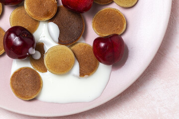 Obraz na płótnie Canvas Homemade cereals mini pancake with yogurt, honey and strawberries on colorful background.