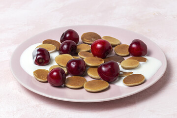 Homemade cereals mini pancake with yogurt, honey and strawberries on colorful background.