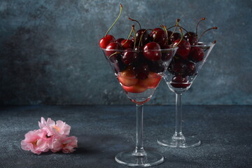 Sweet red and yellow cherries in two glasses. Cherry close-up in a glass with water drops. Summer sweet dessert