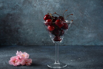 Sweet red and yellow cherries in a glass. Cherry close-up in a glass with water drops. Summer sweet dessert