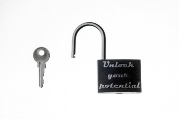 Motivational concept, concept of success, development. On a white background, an open black lock, next to the key lock. Inscription on the lock: "Unlock your potential"