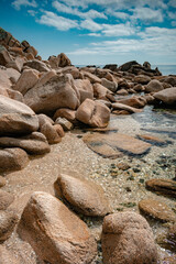 View of the seashore with large stones and marine life under water