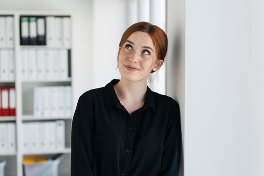 Young businesswoman daydreaming with a smile