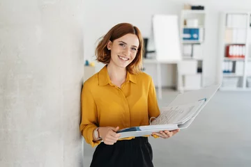 Tuinposter Attractive young office worker holding large file © contrastwerkstatt