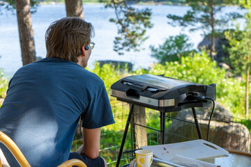 Man and barbecue grill outside