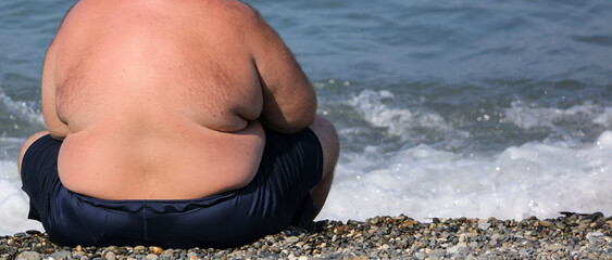 Fat man by the sea in the summer.