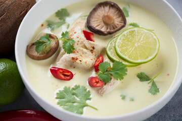 Bowl of tom kha gai or soup with chicken fillet, mushrooms and coconut milk, selective focus, closeup