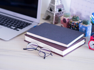 Selective focus eyes glasses with books and laptop on wooden desk. © bosavang
