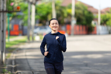 Portrait of Asian woman running at village park