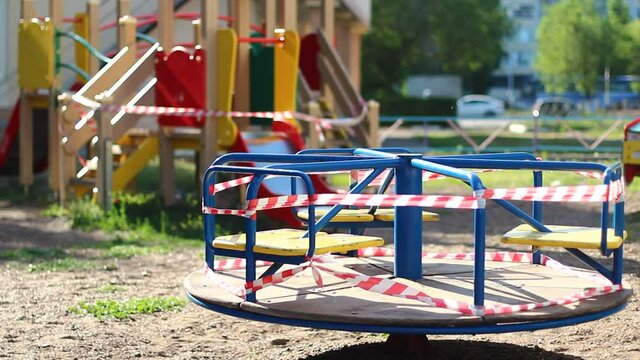 Qurantine on the playground swing with red ribbons