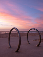 Bicycle racks on the beach at sunset with a beautiful sky