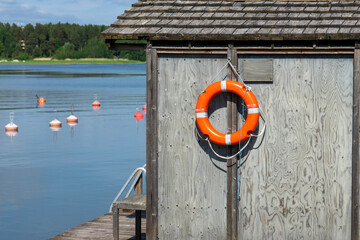 Lifebuoy hanging on the shore blue lake behind and sunny day