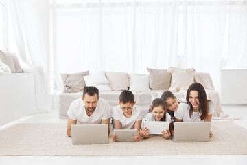 Large family with gadgets. Children and parents at home with a laptop. 