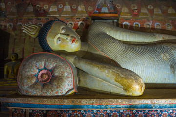 Fragment of a sculpture of the reclining Buddha in the interior of the ancient Buddhist cave temple Rangiri Dambulu Raja Maha Viharaya. Dambulla, Sri Lanka