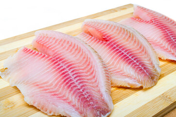 Three filet fish hare, rabbit fish on a cutting board in macro. Dorado fillet, telapia. Raw fish, seafood in macro