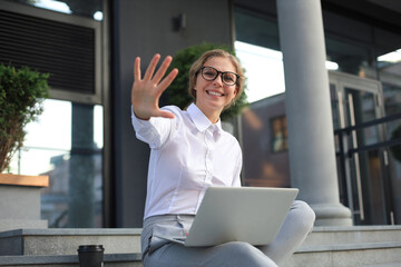 Beautiful business woman sitting near business center and using laptop.