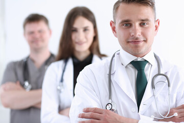 Fototapeta premium Group of medics proudly posing in row and looking in camera smiling. High level service, best treatment, 911, professional, healthy lifestyle, therapeutist consultation, physical, emergency concept