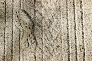 tire and foot tracks in sand background texture with the shadows