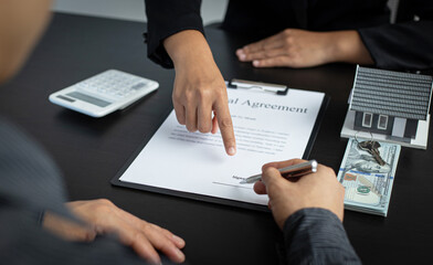 Asian woman asks a man to sign documents in the office.