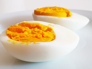 Cut two halves of boiled egg on a white surface.