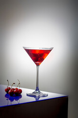 fresh red cherry juice in a wine glass with red cherries 