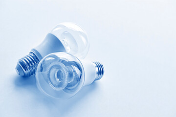 Two transparent LED light bulbs in monochrome blue. Energy saving concept with copy space. Vertical image.	
