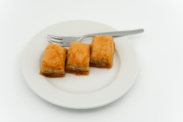 Turkish baklava plate and fork, service presentation on white isolated background.