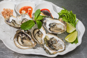 The oysters were placed on a plate with ice and side dishes.
