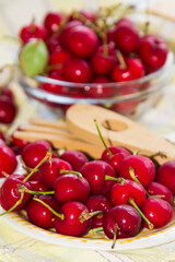 plate of delicious red cherries on the table with tablecloth
