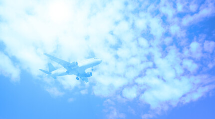 Fototapeta na wymiar Airplane on a background of white clouds. Blue sky