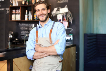 Male business owner behind the counter of a coffee shop with crossed arms, looking at camera. - Powered by Adobe