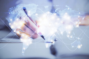 International business hologram over hands taking notes background. Concept of success. Multi exposure