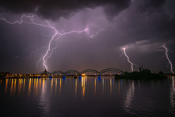 Huge thunderstorm over the city with the powerful lightnings in the sky