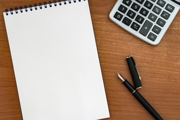 fountain pen with notepad on wooden table